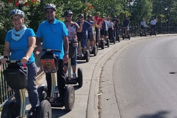 Large group riding on sidewalk with segways